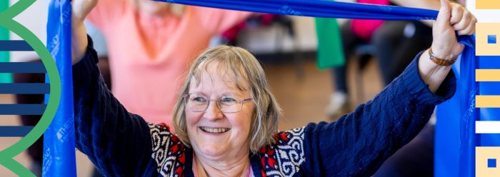 Older woman doing seated exercise with stretchy yoga band 